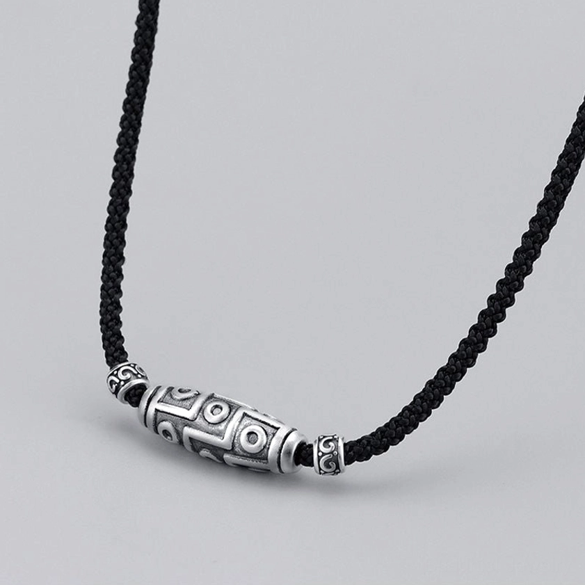 Nine-eye dzi bead buddhist necklace straight front view displaying symmetrical silver caps and carved sacred geometry pattern