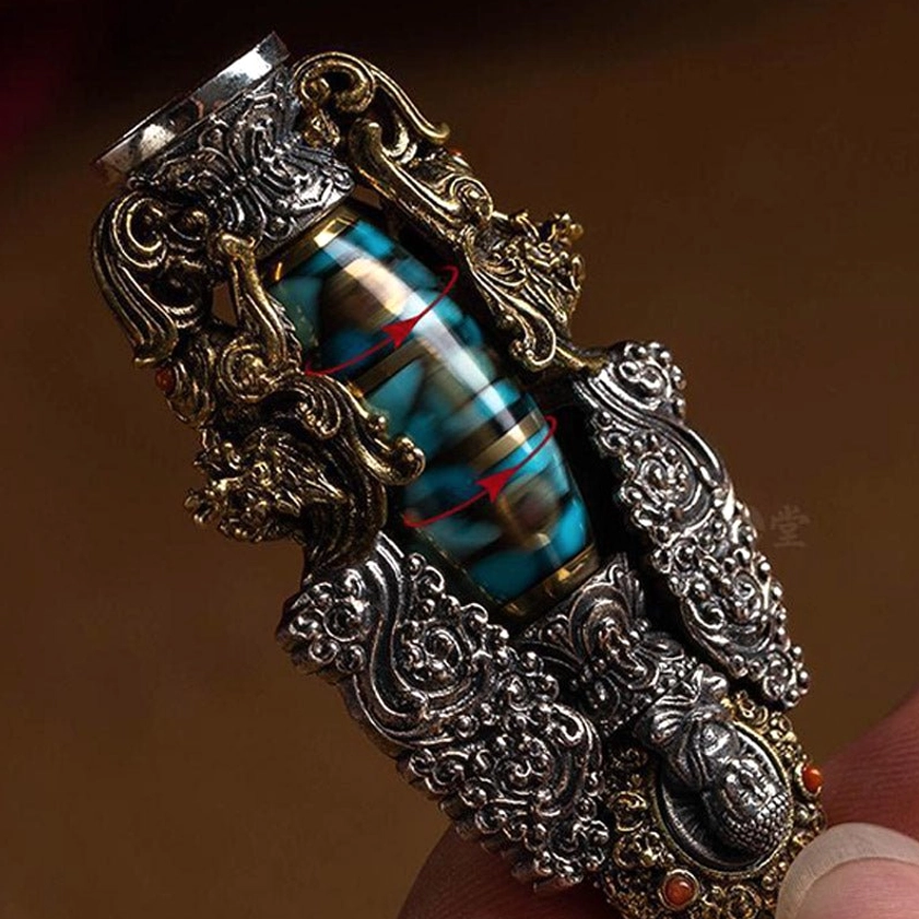 Nine-eye dzi bead pendant side view showing dual-tone metal carvings, turquoise and red inlaid gemstones with dragon-themed spiritual details