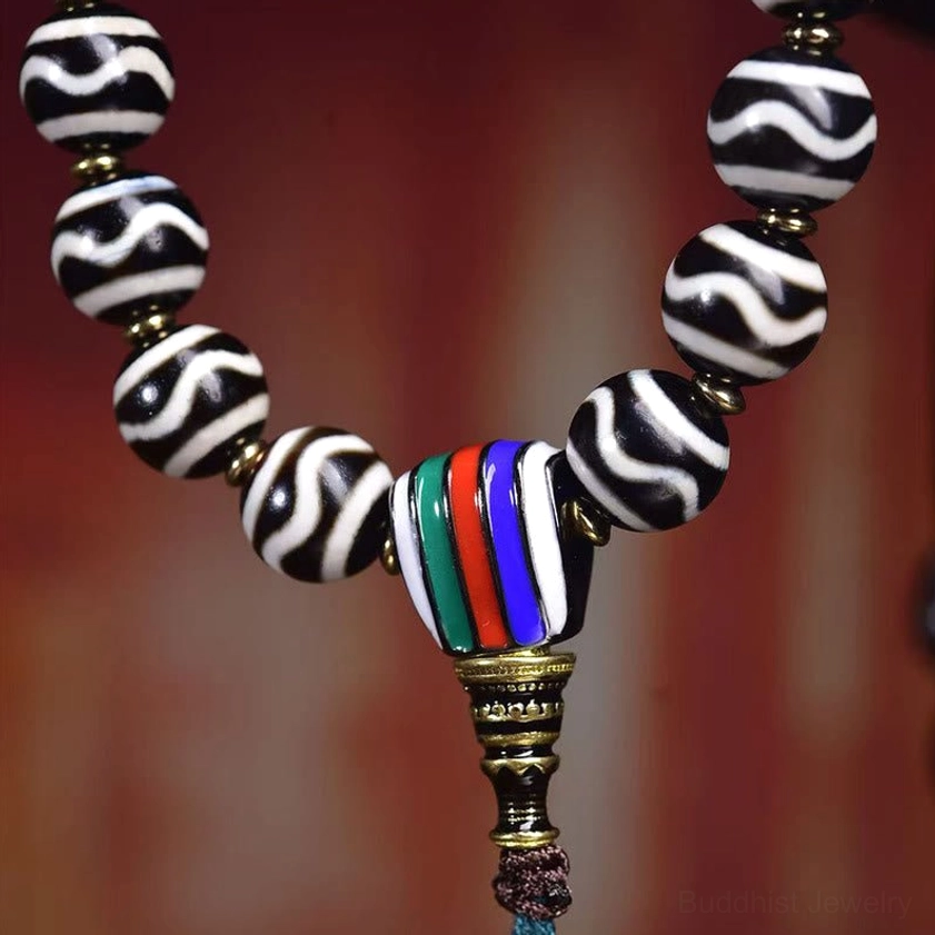 Side view close-up of corpse forest lord dzi bead bracelet showing guru bead and water pattern details