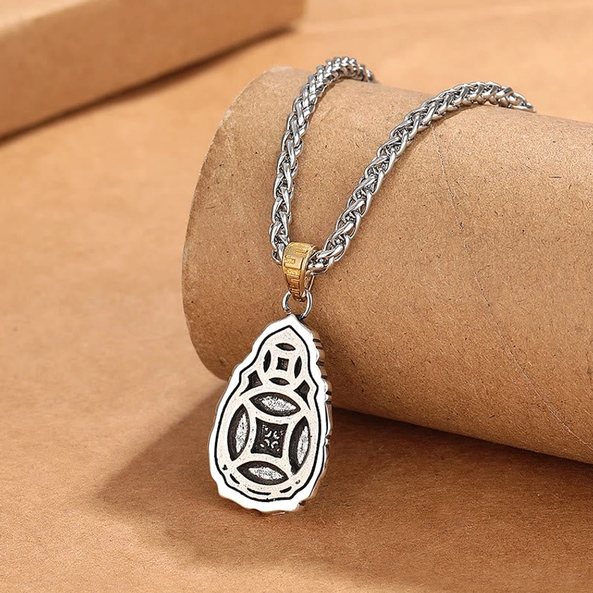 Reversible Dzi bead pendant showing engraved geometric patterns on back with silver wheat chain