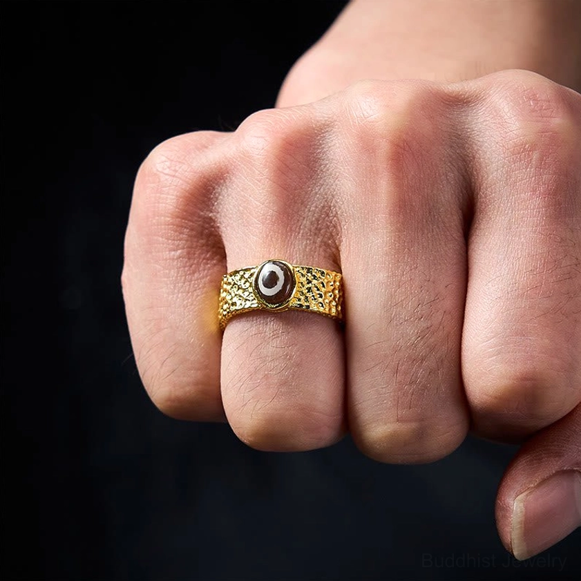 Nine-eye dzi bead adjustable ring worn on hand, demonstrating fit and adjustable open cuff design on middle finger