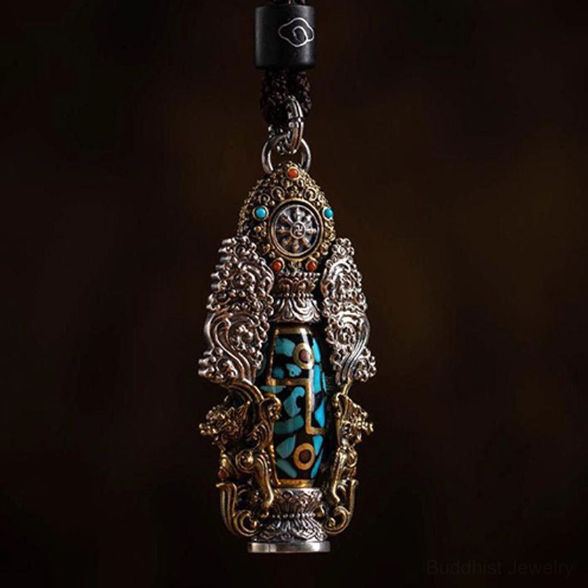 Authentic dzi bead turquoise buddha pendant with ornate metal frame and decorative cord cap, featuring spiritual protection symbols