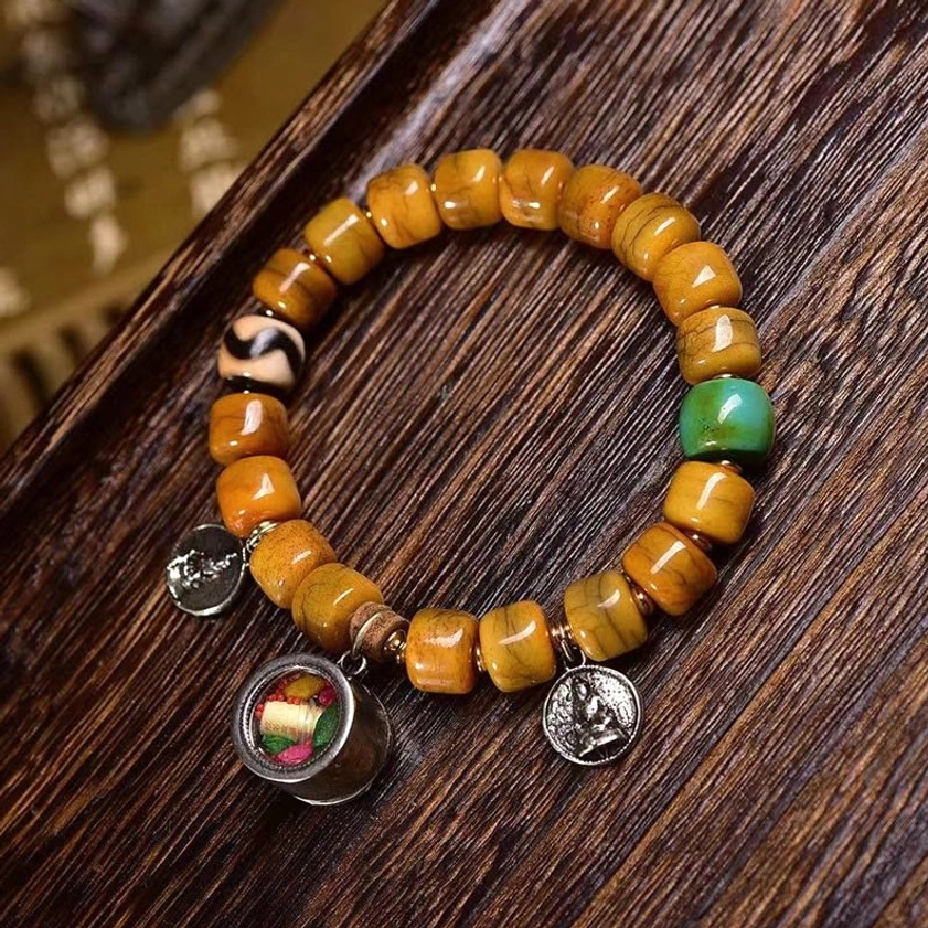 Buddhist protection bracelet featuring bone beads, sacred dzi bead, fox charm, and metal locket