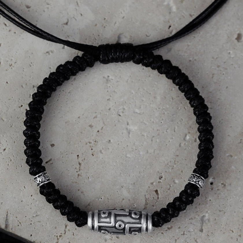 Detail shot of 925 sterling silver decorative end caps and drawstring closure on nine-eye dzi bead bracelet