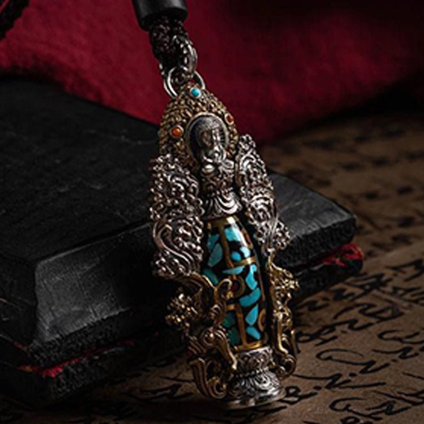 Vintage-style dzi pendant with turquoise inlay design and buddha figurine top, displaying ornate religious craftsmanship and spiritual protection