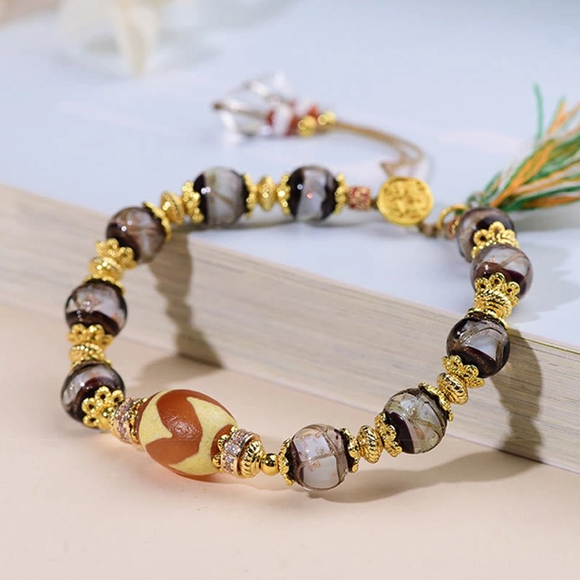 Hand-painted dzi bead bracelet with full design display including tiger-tooth center bead and gold hardware