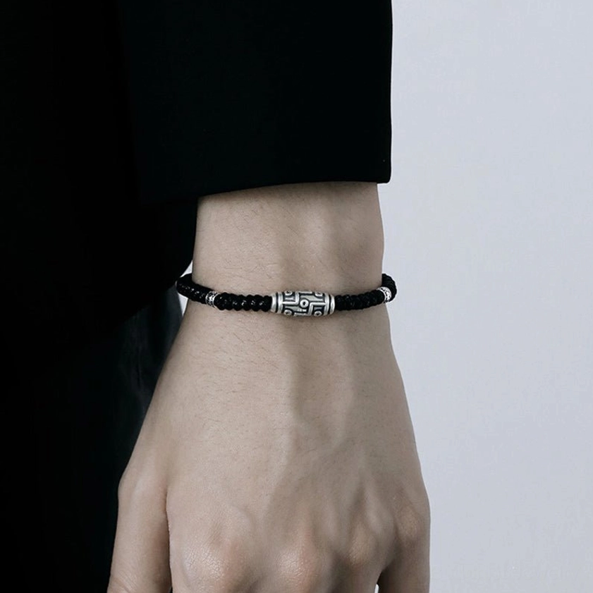 Lifestyle photograph of 999 sterling silver nine-eye dzi bead bracelet with Buddhist spiritual elements in background