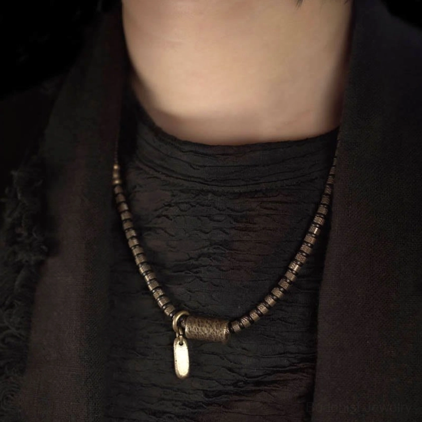 Black ebony beaded bracelet necklace worn around neck showing spiritual jewelry style with copper hardware