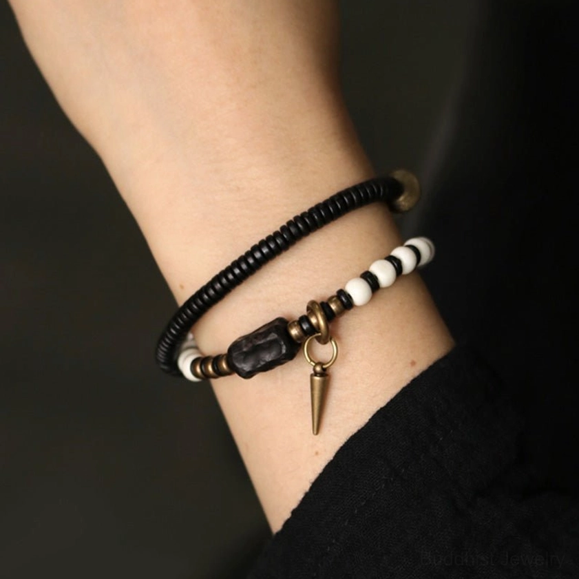 Close-up detail of ebony wood and bone beads with cone pendant charm on wrist