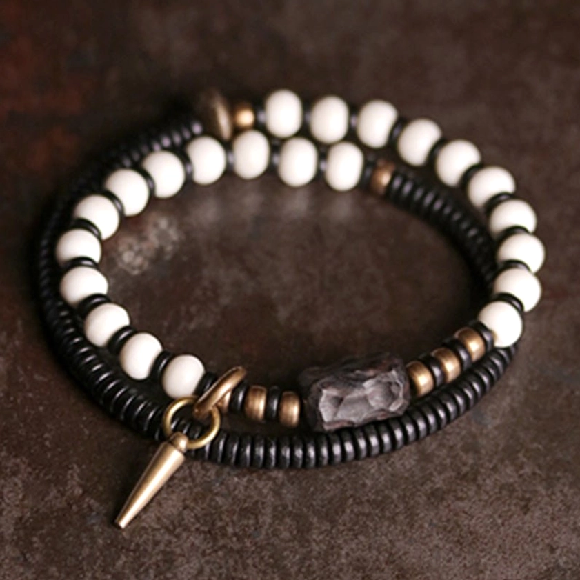 Handmade ebony wood bone bead bracelets displayed on dark leather, showing cone charm detail