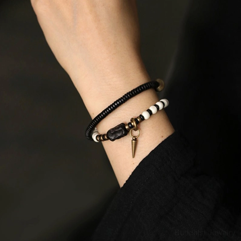 Men's wrist wearing ebony wood and bone bead bracelet with black sleeve, side view