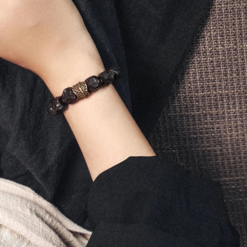 Minimalist ebony wood copper couple bracelet on dark fabric background showing compact beaded fit