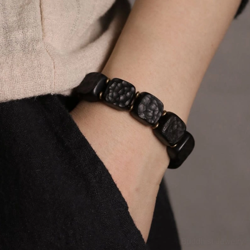 Ebony wood and copper Buddhist bracelet worn on wrist showing natural fit and daily wear appearance