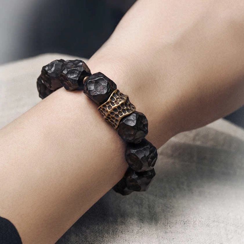 Couple wearing ebony wood copper bracelet on wrist, side view showing carved metal spacer and beaded design