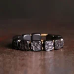 Ebony wood and copper square bead Buddhist bracelet with textured beads and antique bronze metal spacers, overhead flat lay view