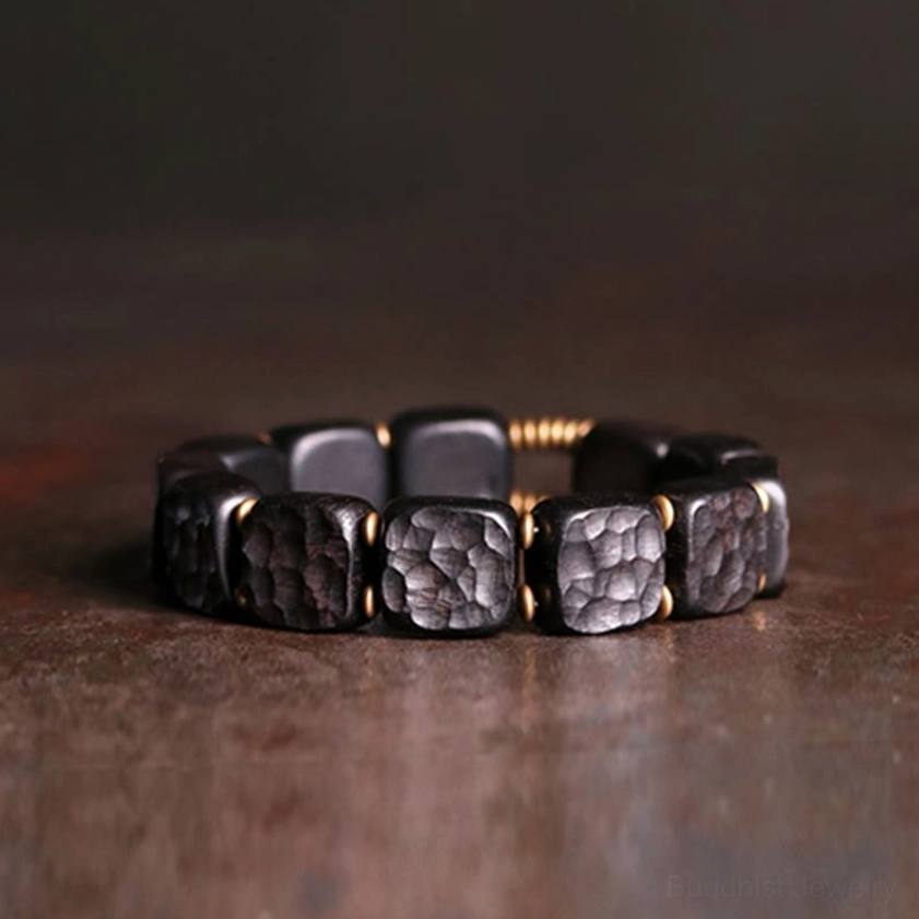Ebony wood and copper square bead Buddhist bracelet with textured beads and antique bronze metal spacers, overhead flat lay view