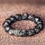 Ebony wood copper couple bracelet with hammered antique bronze beads on brown leather background, spiritual protection jewelry