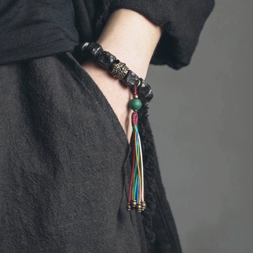 Handcrafted Buddhist prayer mala bracelet worn on wrist with dark linen clothing - lifestyle wear