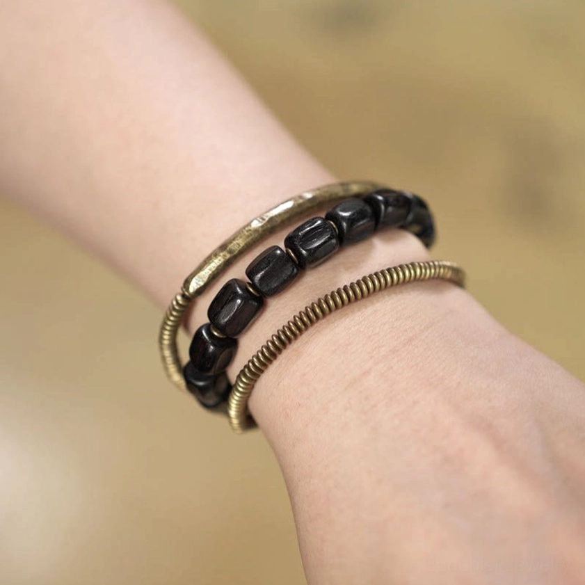 Detailed texture view of ebony wood and copper bead combination on Buddhist bracelet
