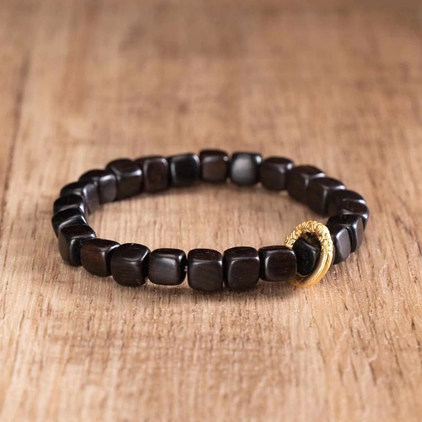 Ebony wood dzi bead bracelet lifestyle image, worn with other jewelry showing versatile spiritual accessory for daily mindfulness practice