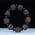 Eighteen Arhats carved ebony wood Buddhist bracelet, overhead view showing detailed arhat face engravings on 20mm beads with black spacers