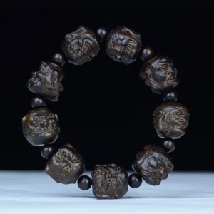 Eighteen Arhats carved ebony wood Buddhist bracelet, overhead view showing detailed arhat face engravings on 20mm beads with black spacers