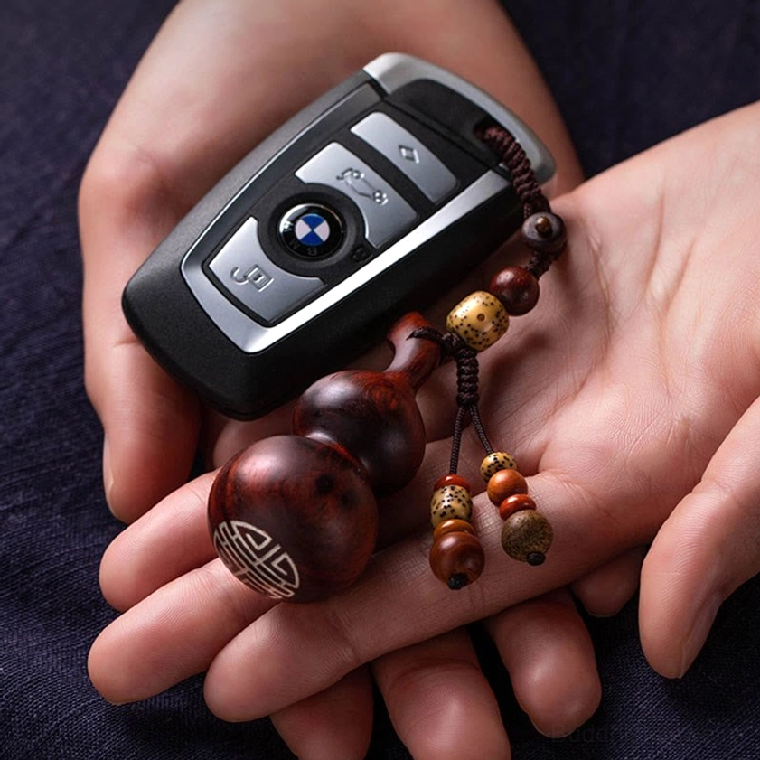 Handcrafted ebony gourd keychain detail shot revealing natural wood grain pattern and traditional Buddhist spiritual craftsmanship