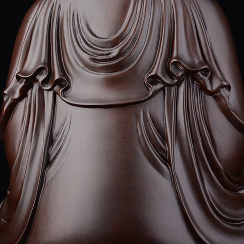 Ebony wood statue robe texture close-up showing deeply carved fabric folds and artisan craftsmanship