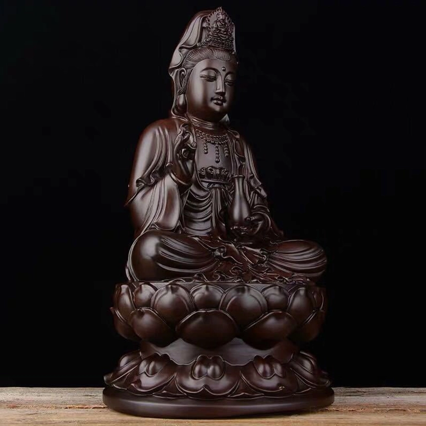 Avalokitesvara ebony wood sculpture left three-quarter angle showing intricate carved robes and serene expression