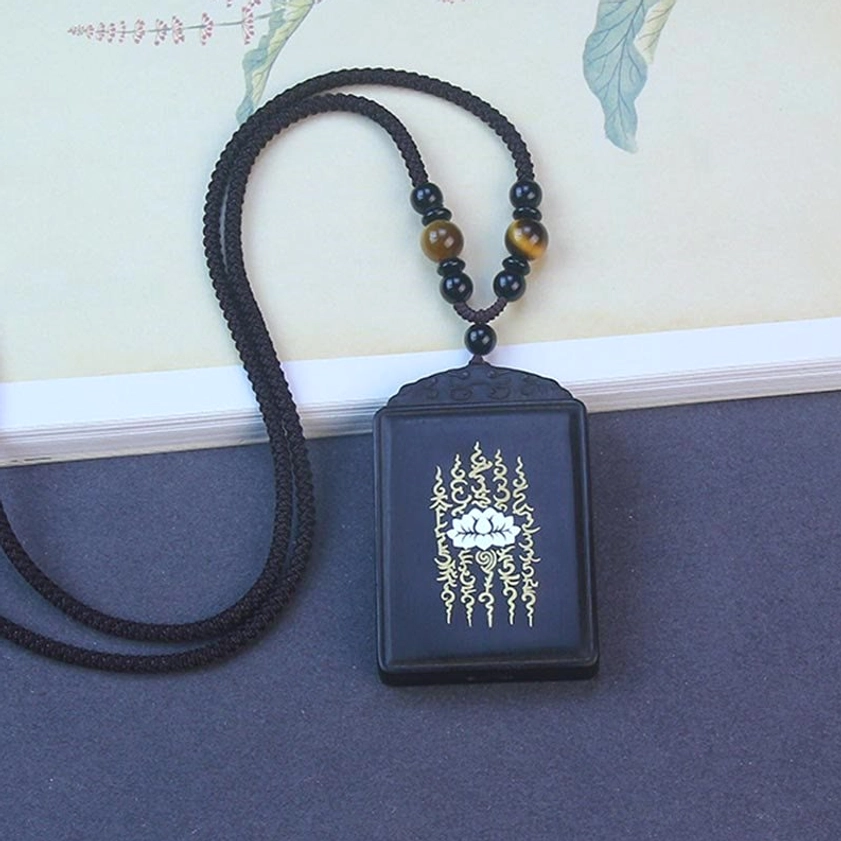 Complete ebony wood lotus pendant necklace set with braided black cord and beaded accents, flat lay display of Buddhist jewelry