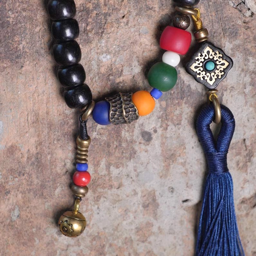 108 bead ebony wood mala bracelet detail shot showing hand-painted dzi bead and copper accents