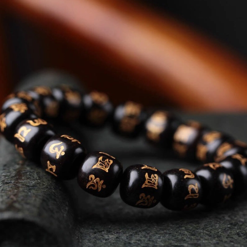 Premium ebony wood Om Mani Padme Hum bracelet close-up side view highlighting polished texture and Sanskrit pattern engravings