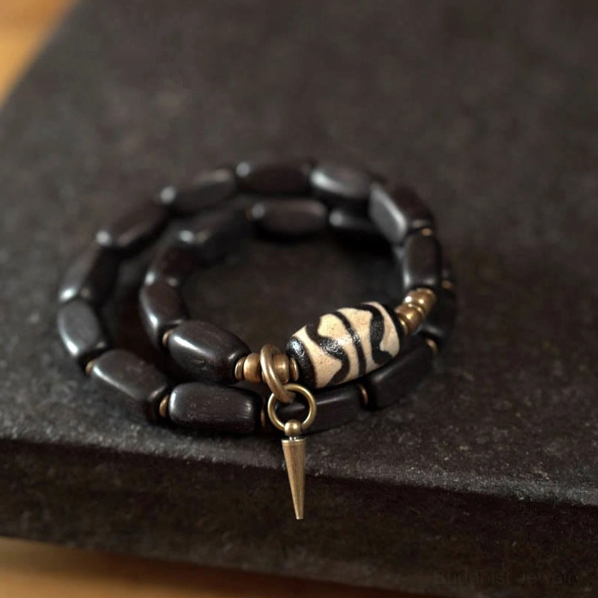 Ebony wood oval dzi bead bracelet with striped tiger eye pattern and bronze spike charm