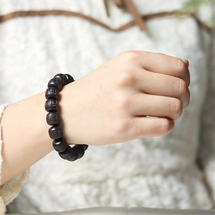 Woman wearing ebony wood bracelet on wrist with knit fabric showing how Buddhist bracelet fits comfortably