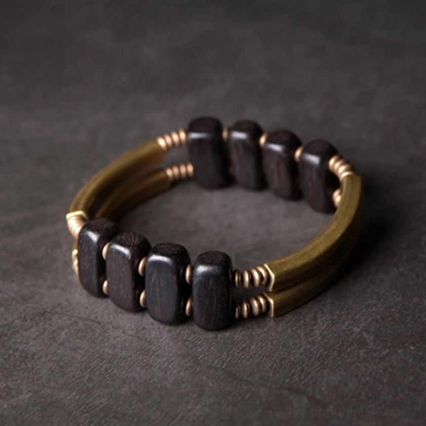 Flat lay view of ebony wood and brass double-layer Buddhist bracelet with metal coil connectors