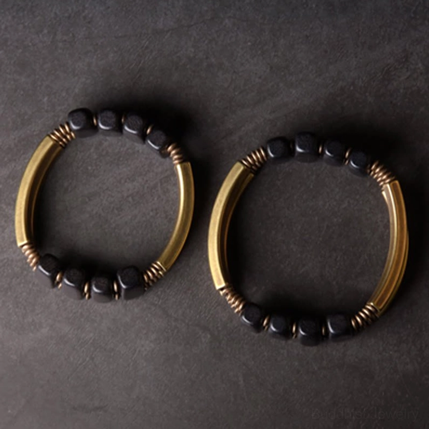 Dark ebony wood and brass Buddhist bracelet displaying natural wood grain and metal craftsmanship