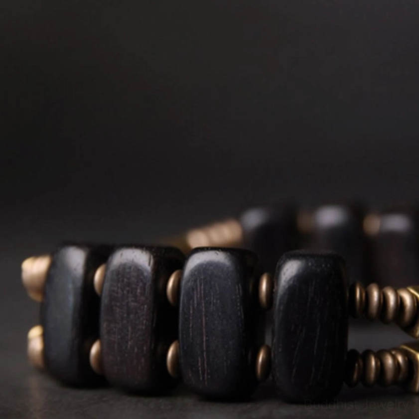 Close-up of ebony wood Buddhist bracelet showing square wood bead craftsmanship and brass metal spacers