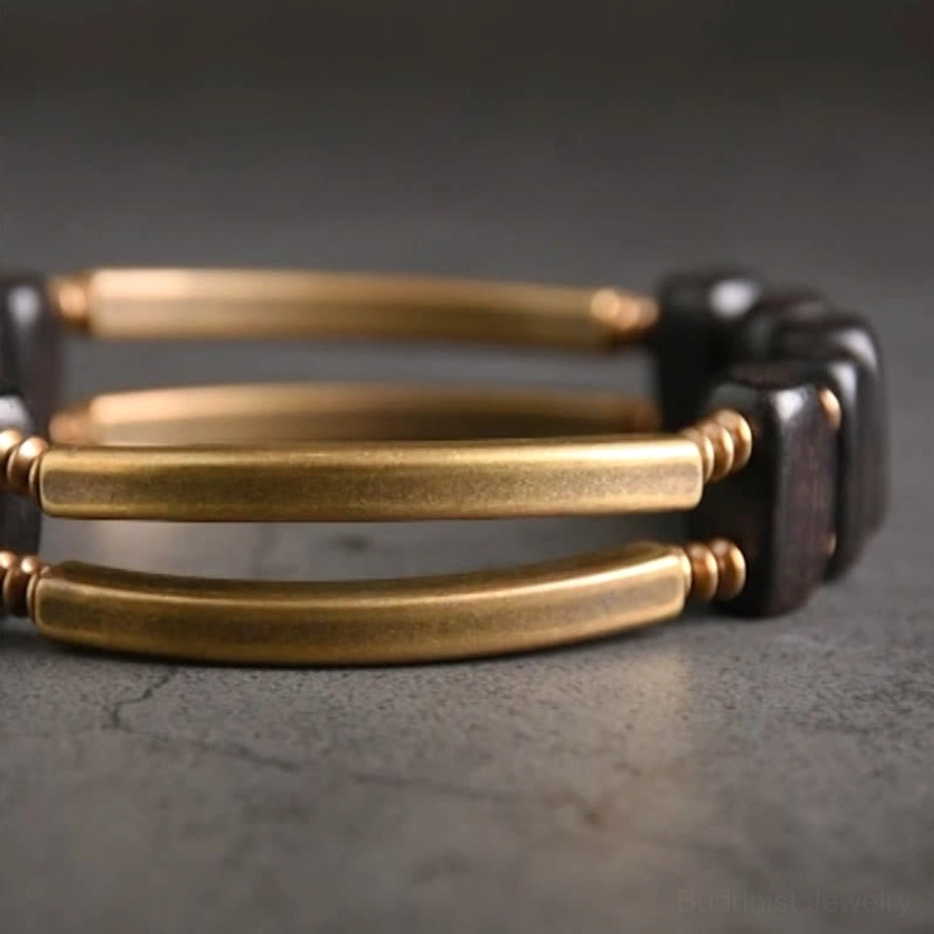 Triple-bar double-layer ebony wood and brass Buddhist bracelet design from top-down angle