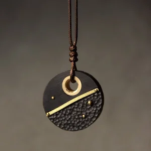 Handcrafted ebony wood and brass Buddhist peace pendant necklace - round design with hammered texture and brass detailing, front hanging view