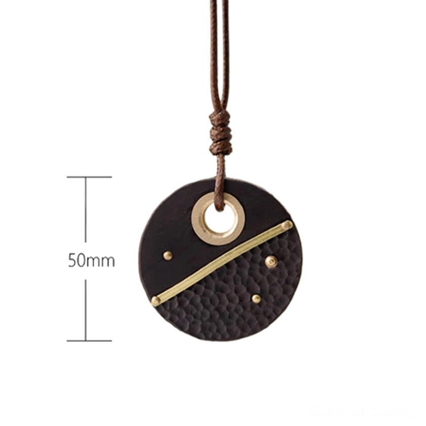 Ebony wood Buddhist peace pendant necklace detail shot showing premium materials, brass accents, and artisanal craftsmanship