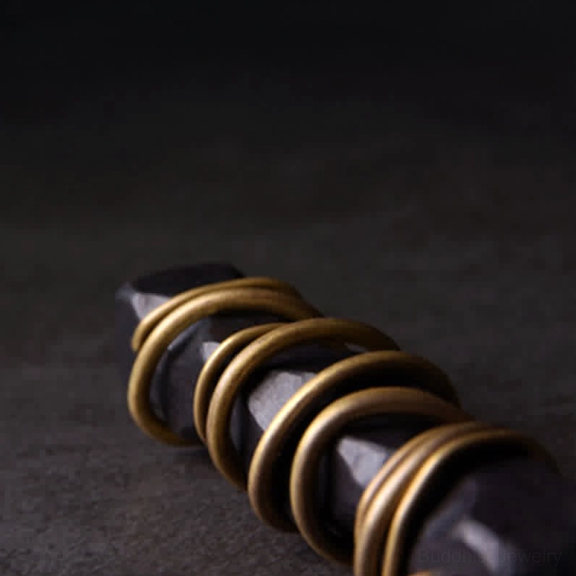 Glossy brass metal and dark ebony wood grain detailed close-up of zen circle pendant