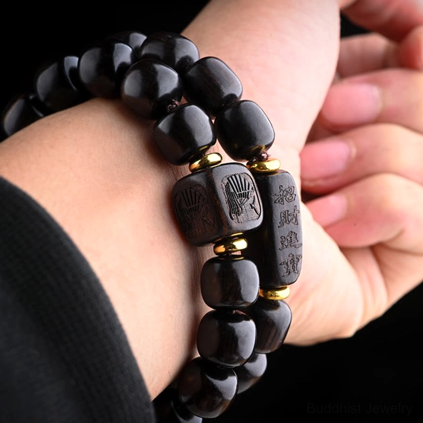 Ebony wood Buddhist bracelet close-up showing smooth barrel bead texture and decorative carved elements
