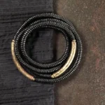 Ebony wood Buddhist bracelet with copper accents, multilayered wrap design displayed on dark surface