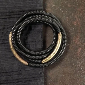 Ebony wood Buddhist bracelet with copper accents, multilayered wrap design displayed on dark surface