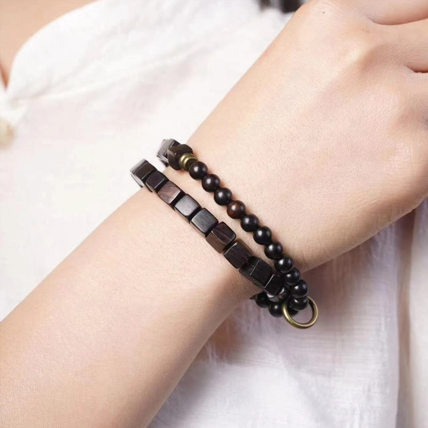 Ebony wood double wrap Buddhist bracelet worn on wrist side view showing natural wood grain and daily wear styling