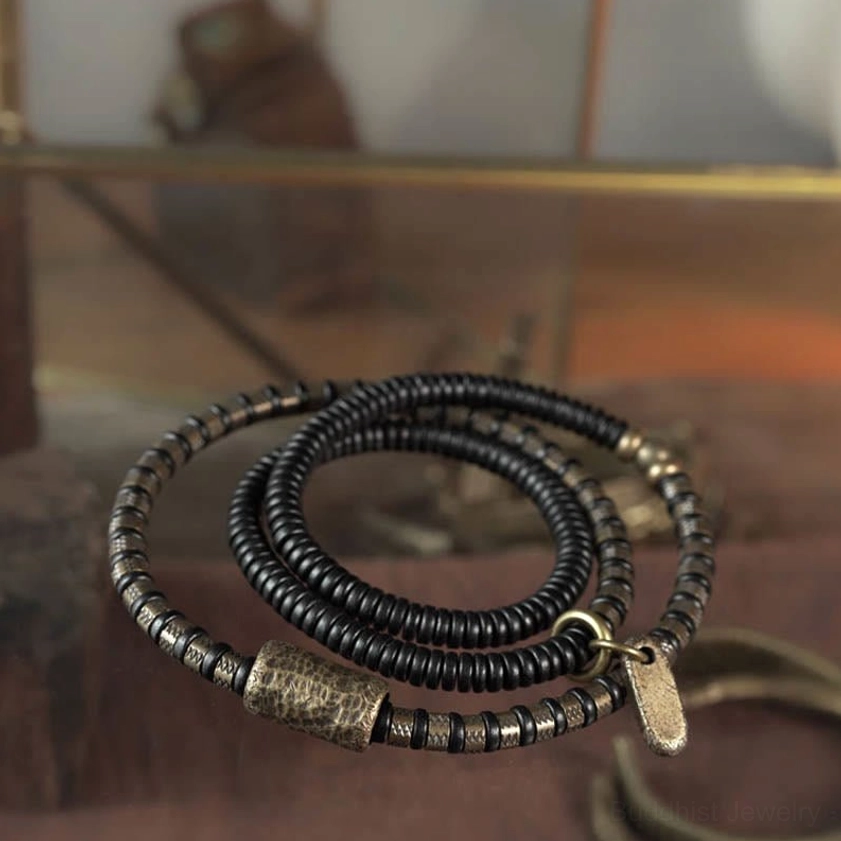 Multilayered ebony wood beaded bracelet coiled display showing antique copper accents and spiritual jewelry design