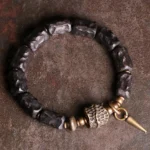 Ebony wood copper couple bracelet flat lay featuring dark beads with antique bronze spike pendant and metal accents for protection and balance