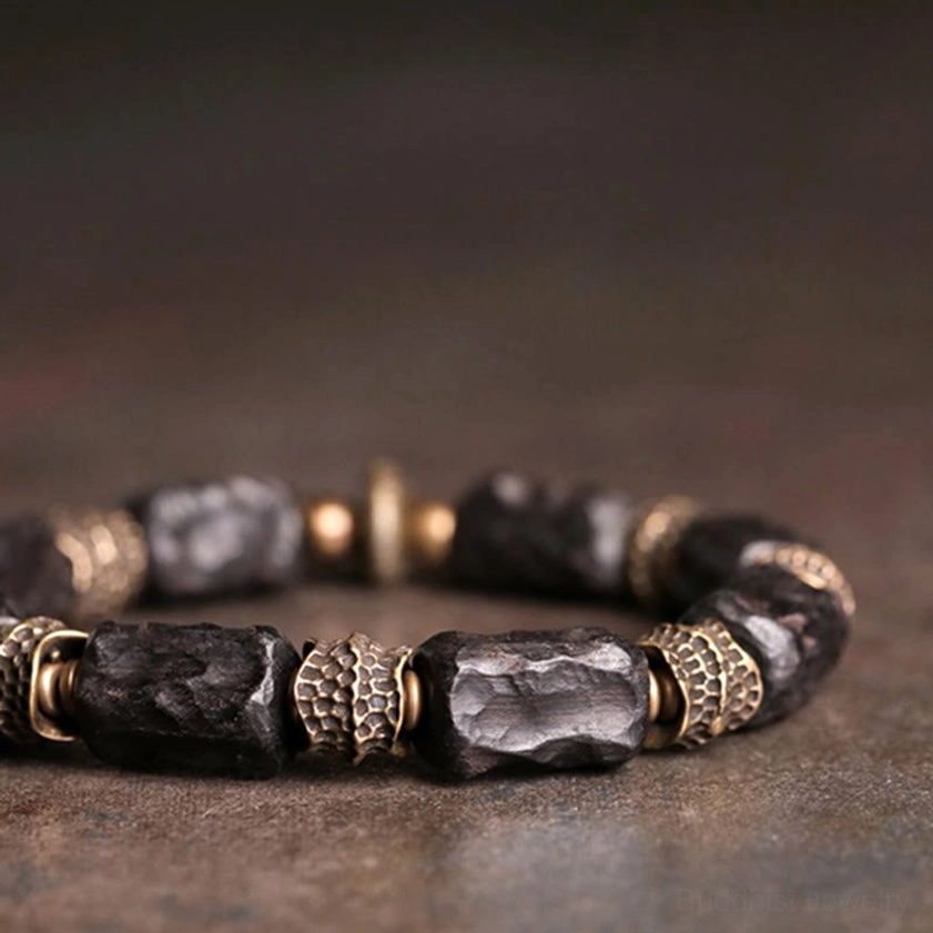Close-up detail of ebony wood beads and copper metal spacers on Buddhist bracelet