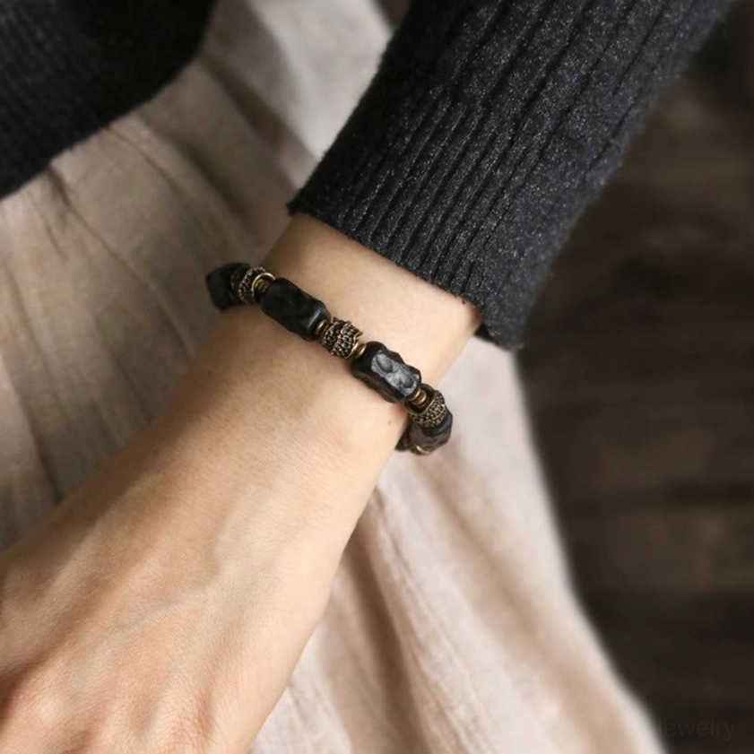 Ebony wood copper Buddhist bracelet styled with casual sweater outfit