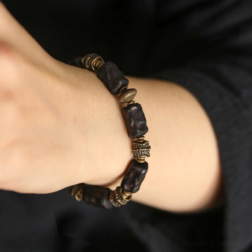 Buddhist bracelet with ebony wood and copper worn on wrist side view